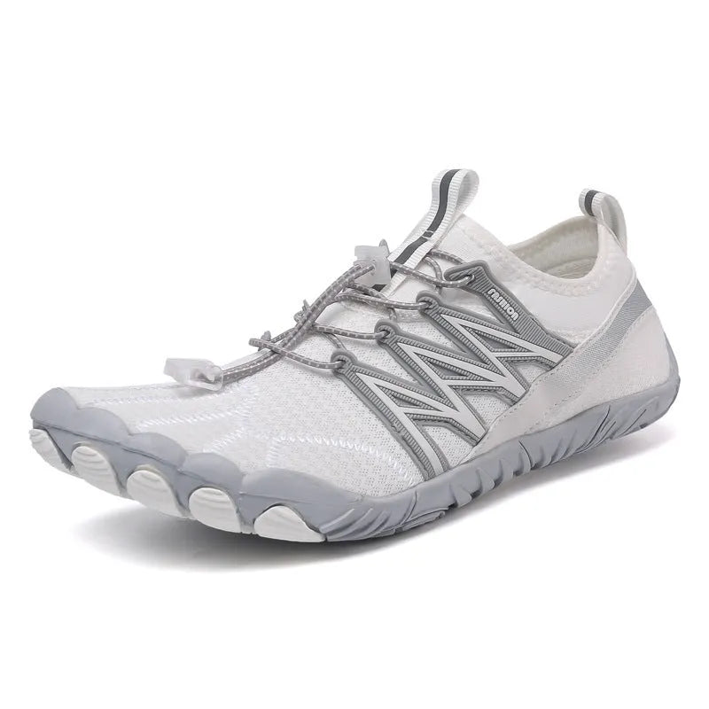 Low-top black and grey indoor training sneakers with mesh upper and rubber sole on a gym floor.