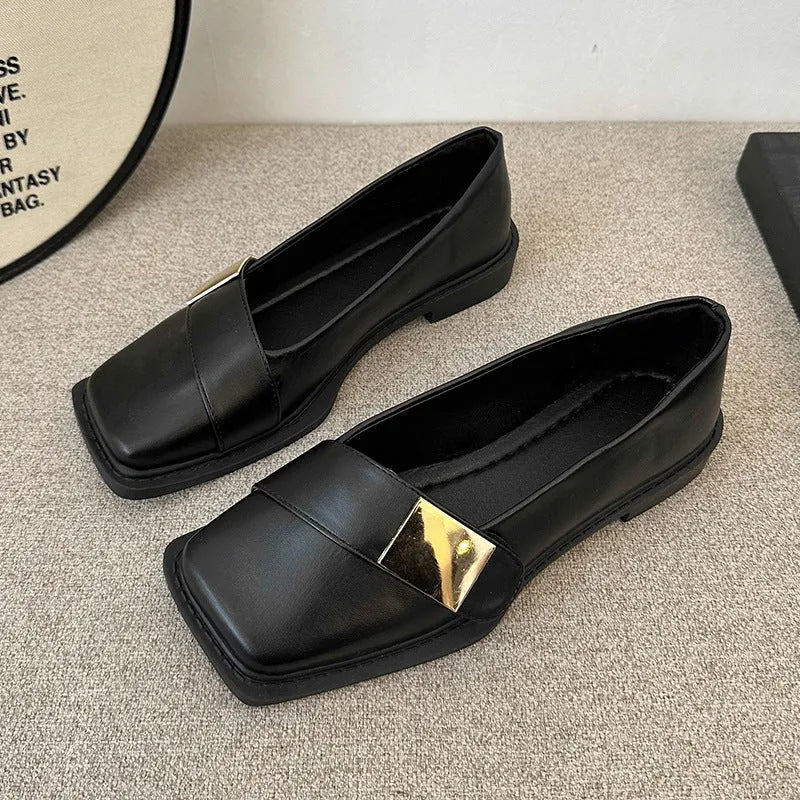 Women's beige square toe flat heel loafers with a silver metal buckle on the upper.