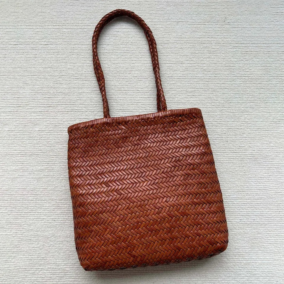 Brown woven leather tote bag with three-dimensional pocket, showing 27x30x6cm dimensions and handmade construction