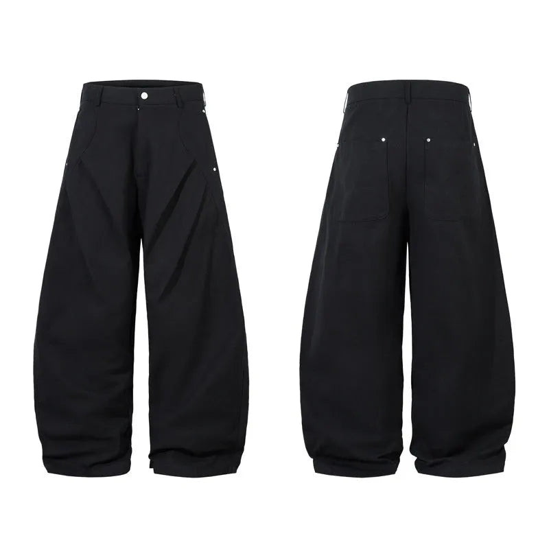 Men's black pleated machete casual trousers with a loose wide-leg fit on a neutral background.