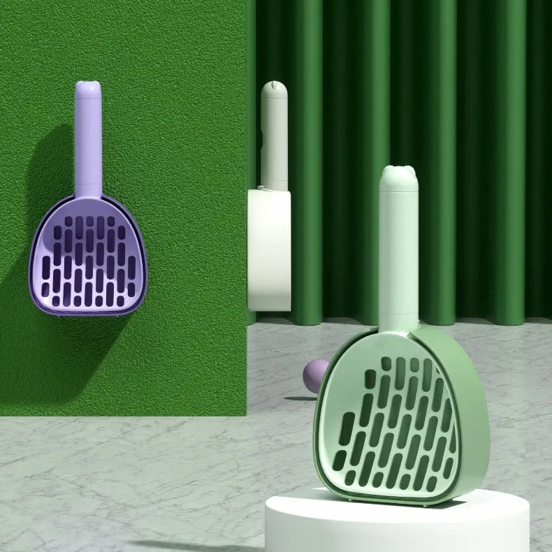White ABS plastic cat litter scoop standing on a matching storage base with integrated waste bag roll.