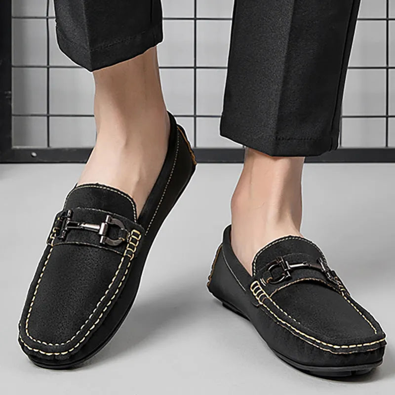 Men's beige slip-on loafers with a round toe and rubber sole on a plain background.