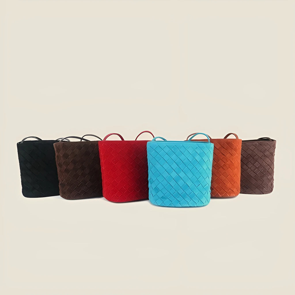 Cowhide leather women's crossbody bag with barrel shape, zip closure, woven detail, and inner patch pocket.