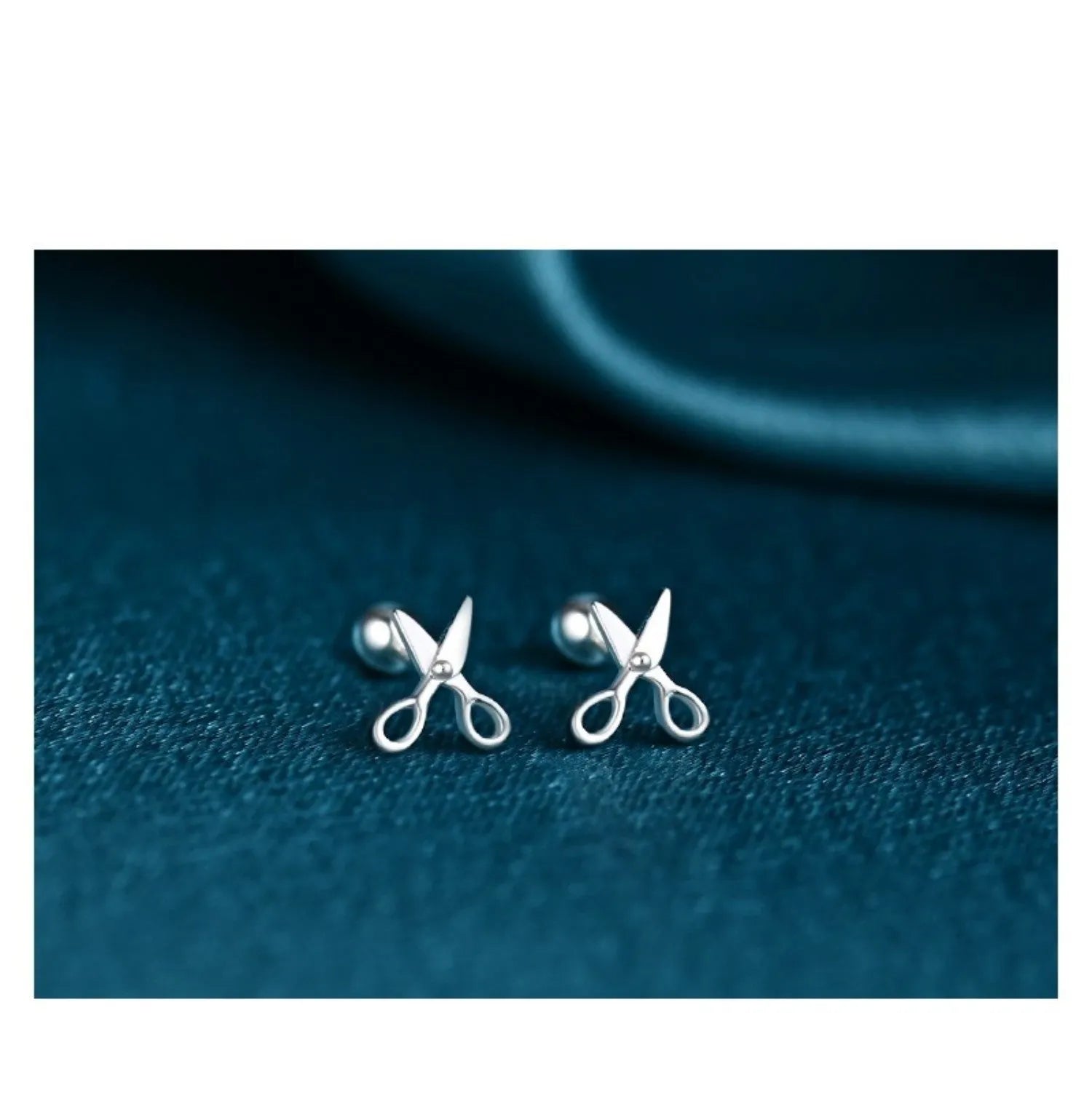 A pair of S999 pure silver earrings with screw-style closure shaped like miniature scissors.