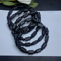 Unisex black tourmaline rough stone bracelet on wrist, showing natural texture and 10mm band width.