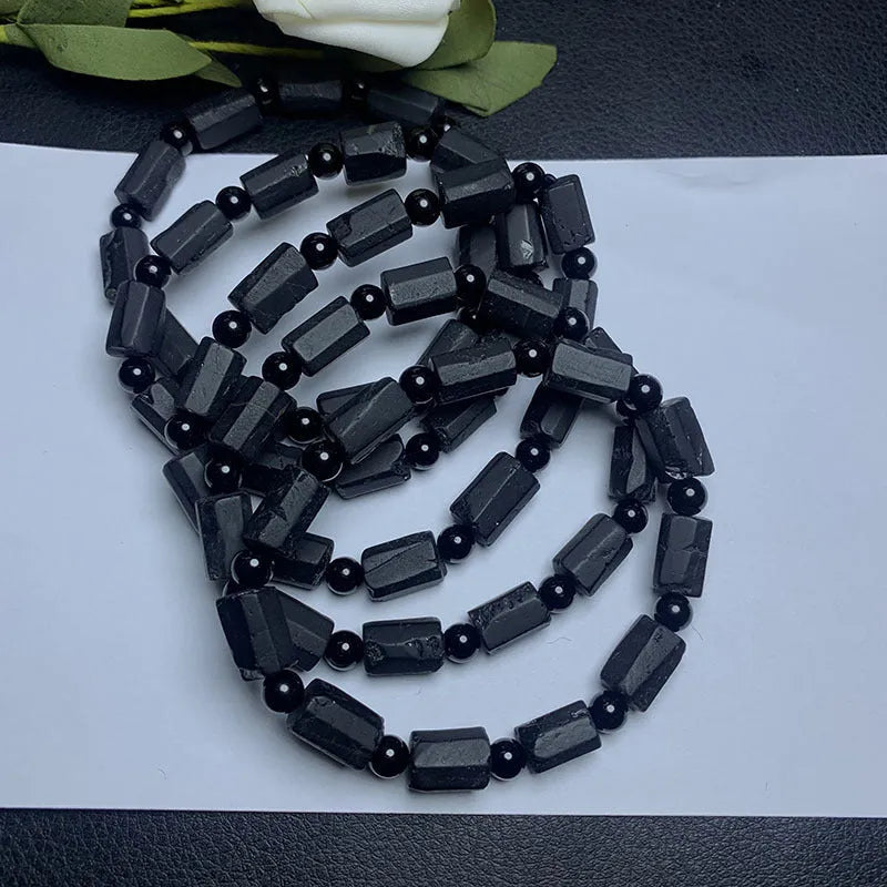 Unisex black tourmaline rough stone bracelet on wrist, showing natural texture and 10mm band width.