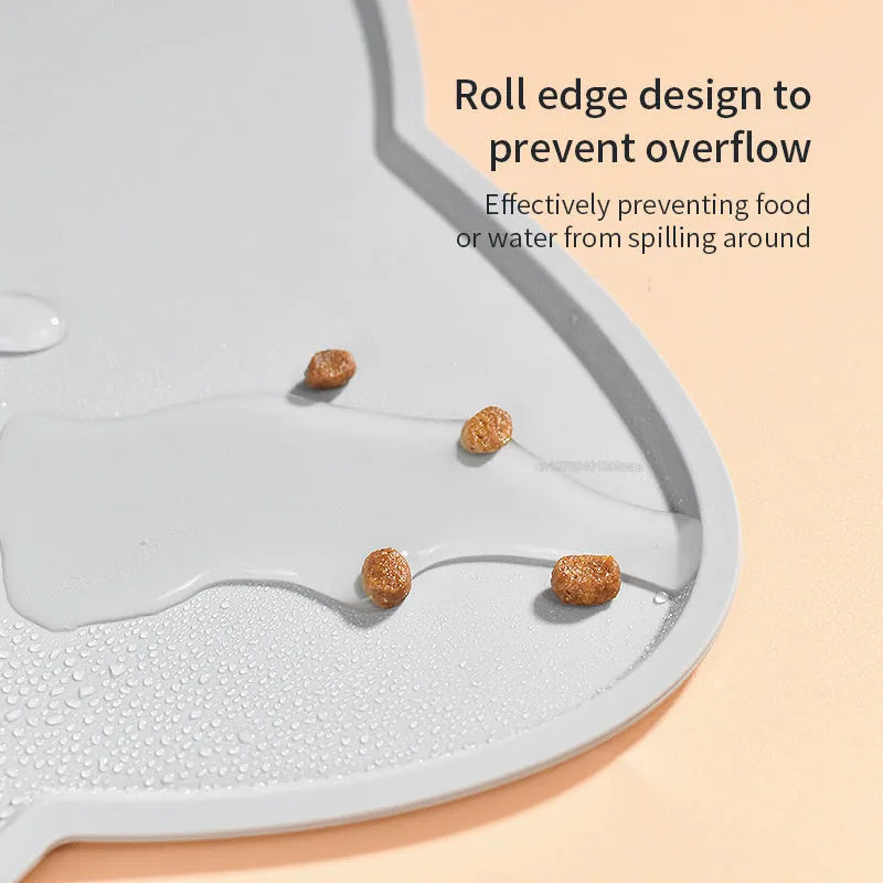 Blue cat head shaped silicone pet feeding mat placed under food and water bowls.