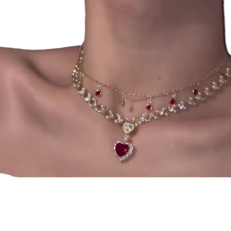 Red double layer necklace with two chains, a heart pendant, and an adjustable clasp.