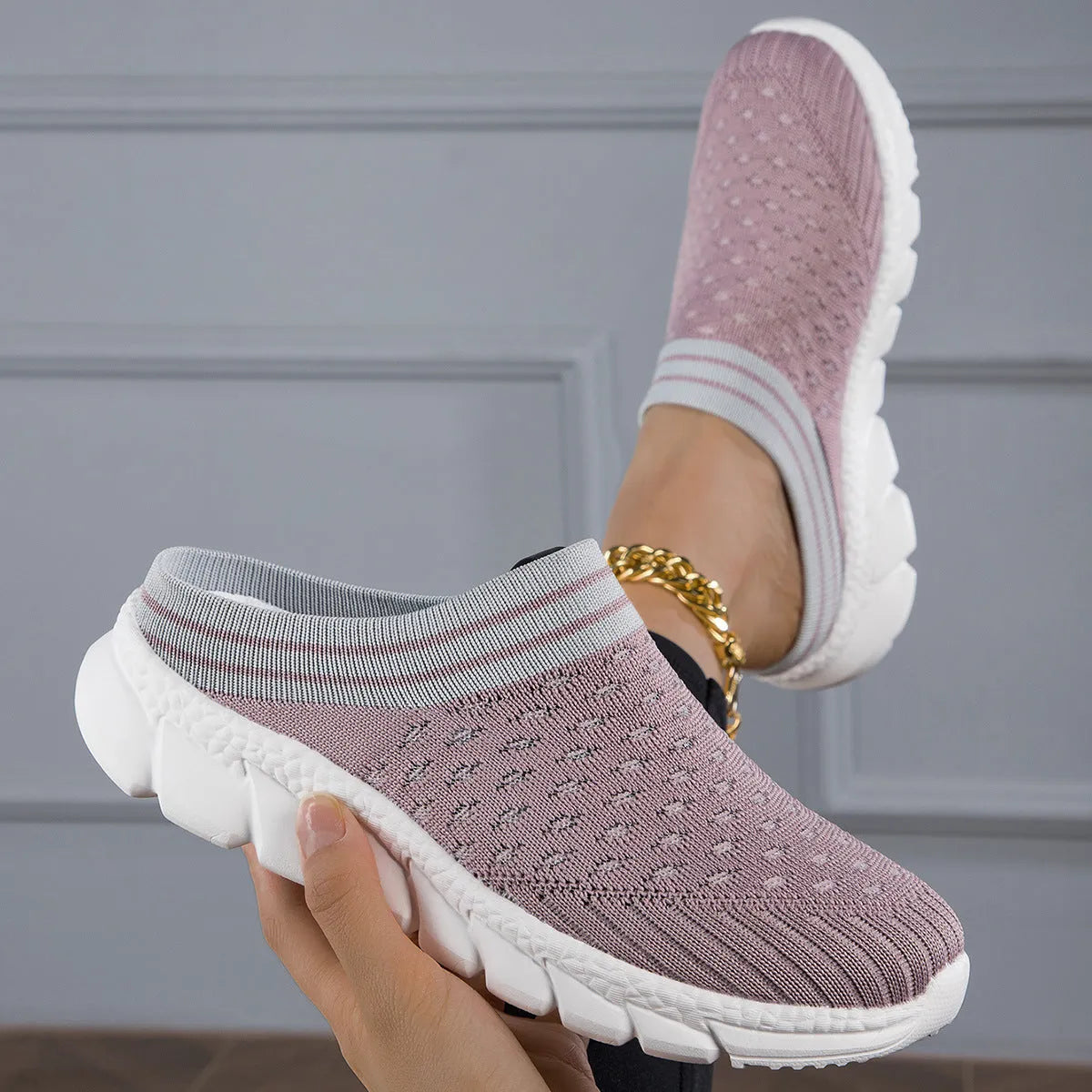 Women's black Flyknit slipper shoes with striped pattern and hollowed-out design on a white background.