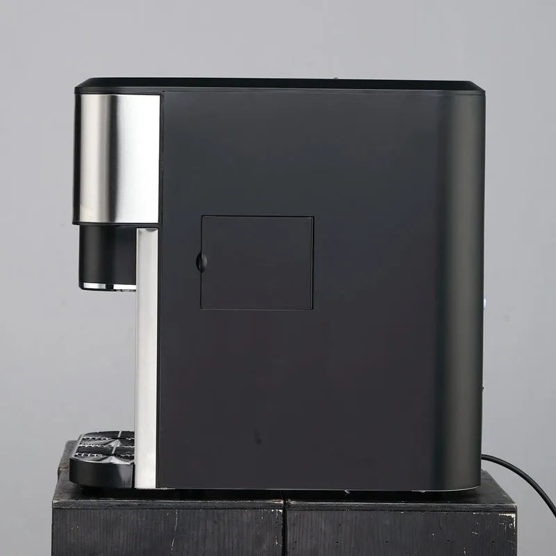 Black desktop ice maker machine with stainless steel interior on a kitchen countertop