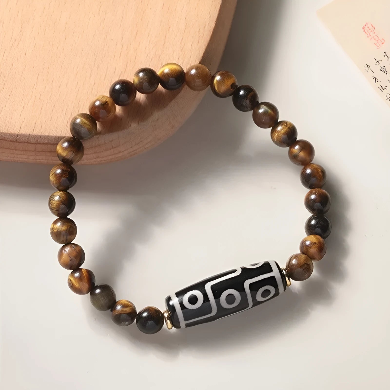 Close-up of a single circle tigereye stone Buddha rosary bracelet showing the chatoyant beads on a string.