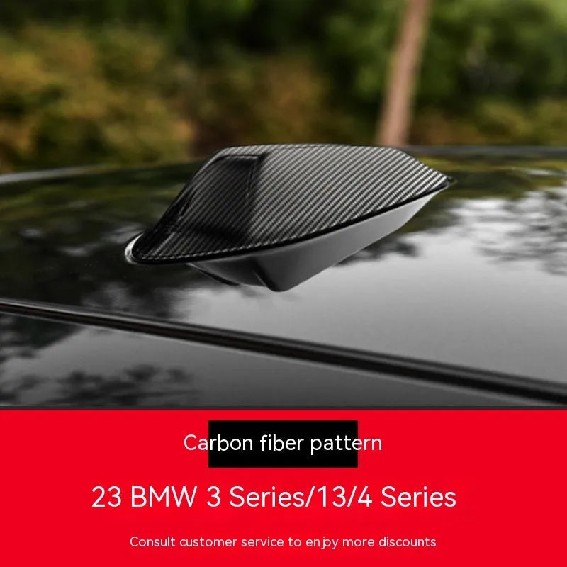 BMW shark fin antenna cover in carbon fibre and piano black finishes on a car roof.