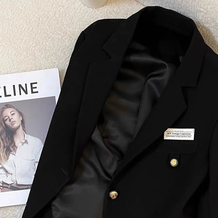 Women's black short suit coat with loose fit, long sleeves, and pocket details, shown in a commuting style.