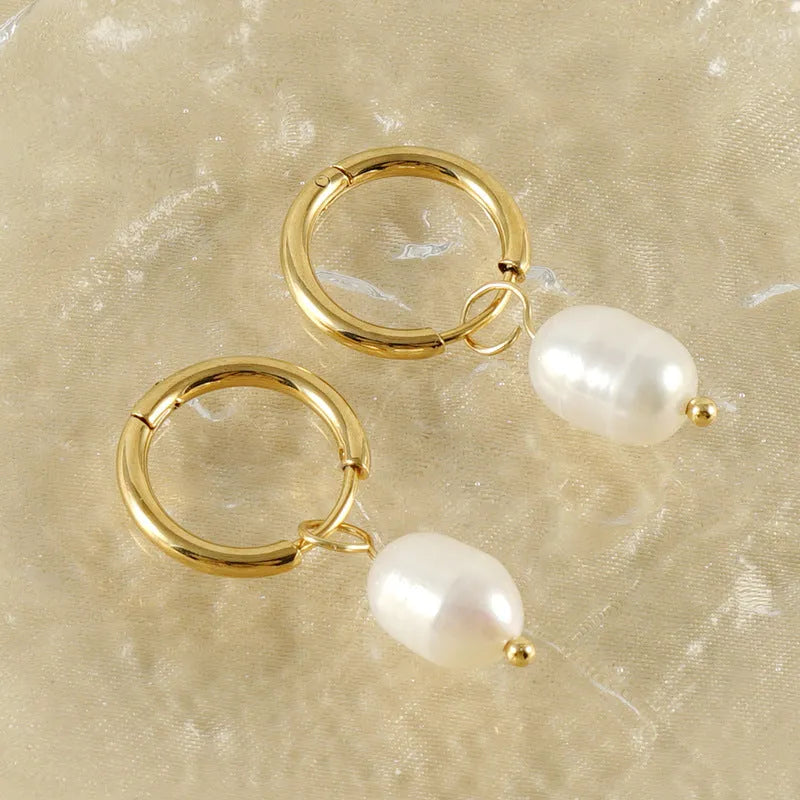 Gold geometric earrings with freshwater pearl accent on stainless steel background