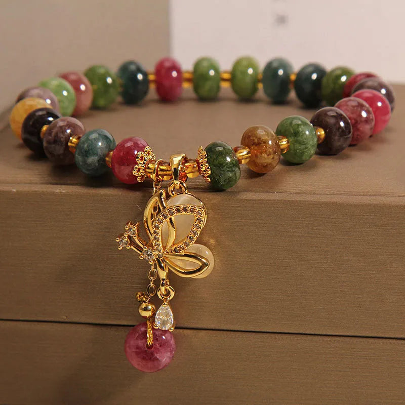 Colourful women's alloy bracelet with multicoloured beads and a butterfly charm on a wrist.