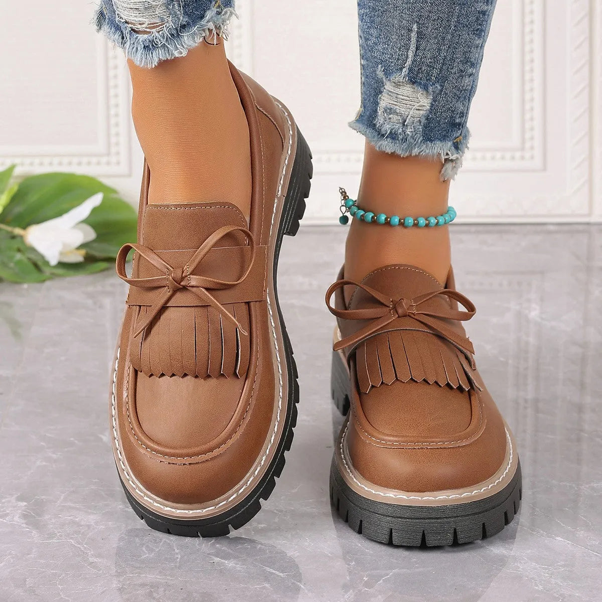 Women's black plus size loafers with tassel and bowknot, chunky heel, and round toe on a rubber sole