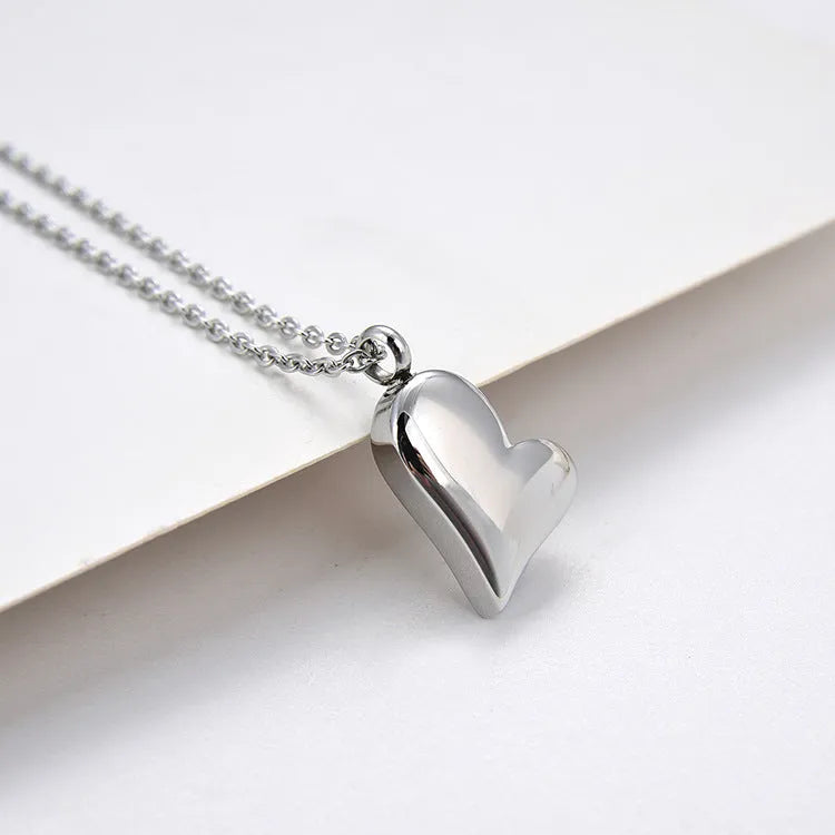 Silver curved peach heart pendant on adjustable stainless steel necklace, 51cm chain with 5cm extension