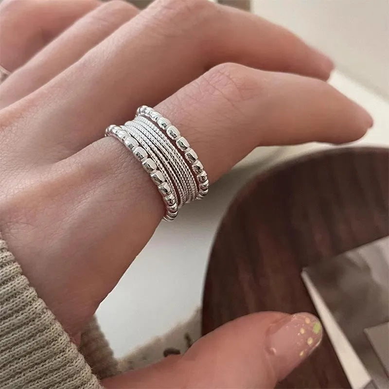 Close-up of an adjustable woven twisted multilayer copper ring with a geometric shape.