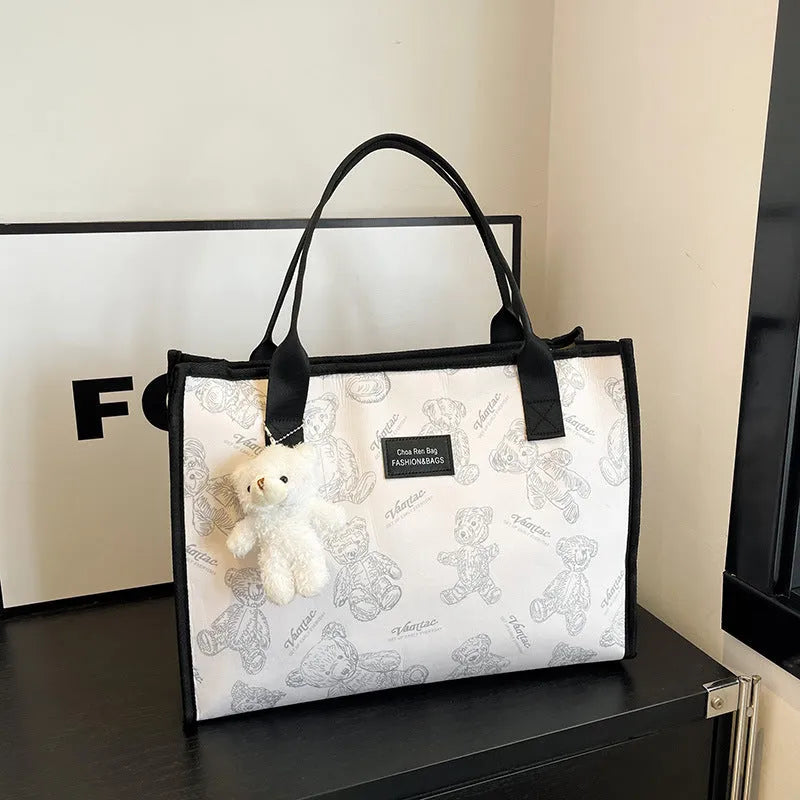 Women's black canvas tote with rhombus pattern showing 40cm width and horizontal square shape with shoulder strap