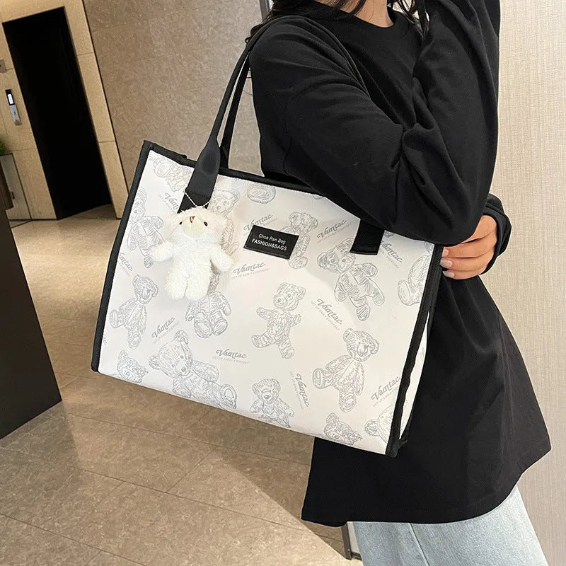 Women's black canvas tote with rhombus pattern showing 40cm width and horizontal square shape with shoulder strap