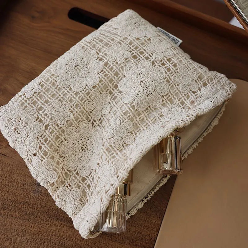 Handmade crocheted floral cosmetic bag with ethnic embroidery on corduroy fabric, showing woven patterns and cutout designs