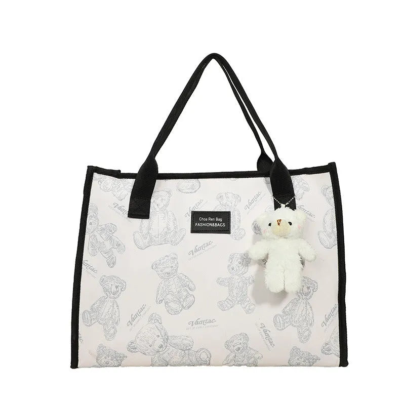 Women's black canvas tote with rhombus pattern showing 40cm width and horizontal square shape with shoulder strap