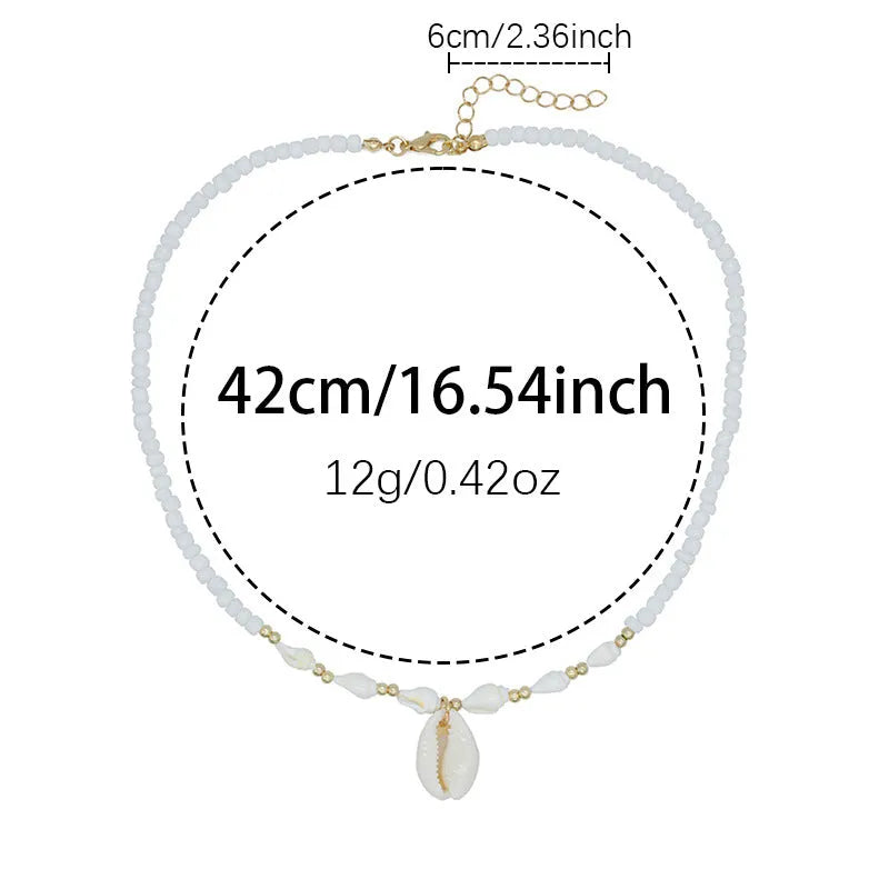 White shell necklace with conch-shaped pendant on adjustable chain, showing mother-of-pearl texture.