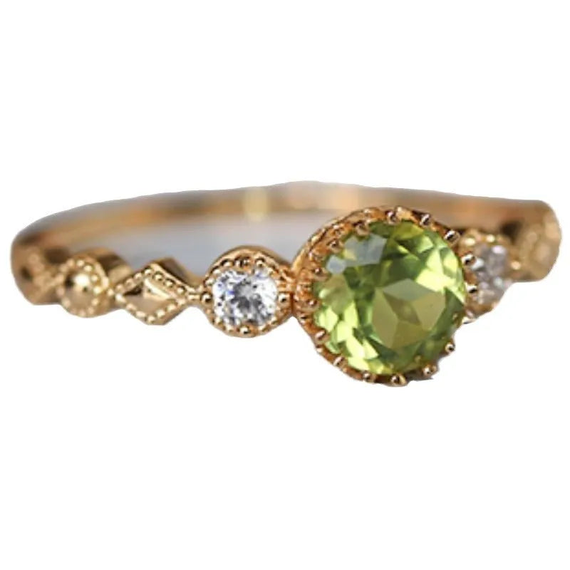 Quadrilateral geometric copper ring with imitation peridot stone, showing angular design and metallic finish