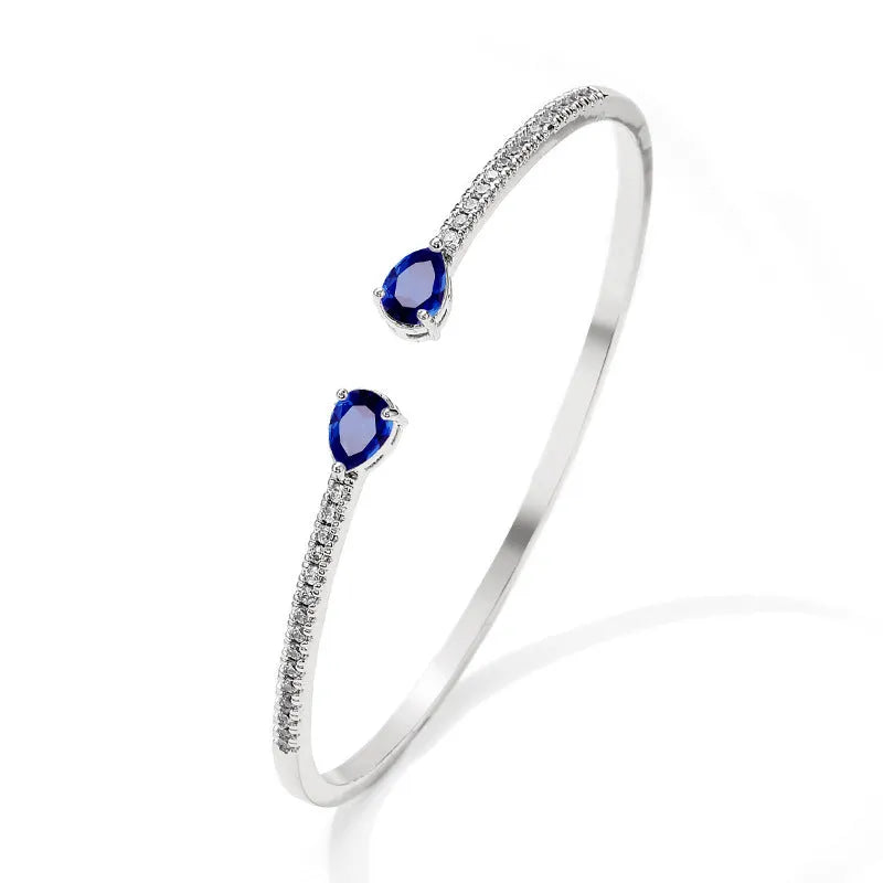 Copper bracelet with inlaid zircon stones in white or blue colour on a simple band