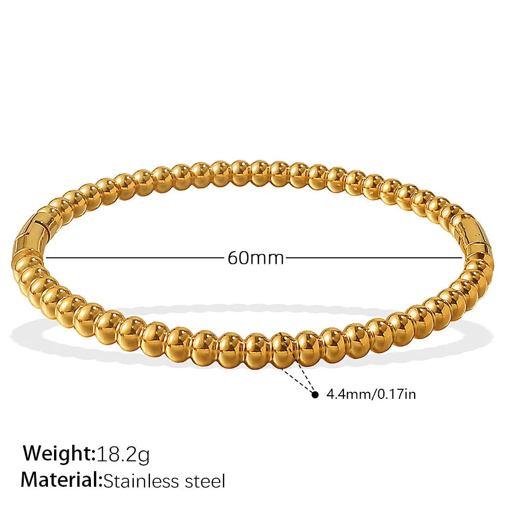 Stainless steel open-end bracelet with a buckle closure and circle design, shown in an electroplated gold colour.