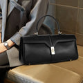 Women's cylindrical cowhide leather messenger bag in black or caramel colour with retro styling