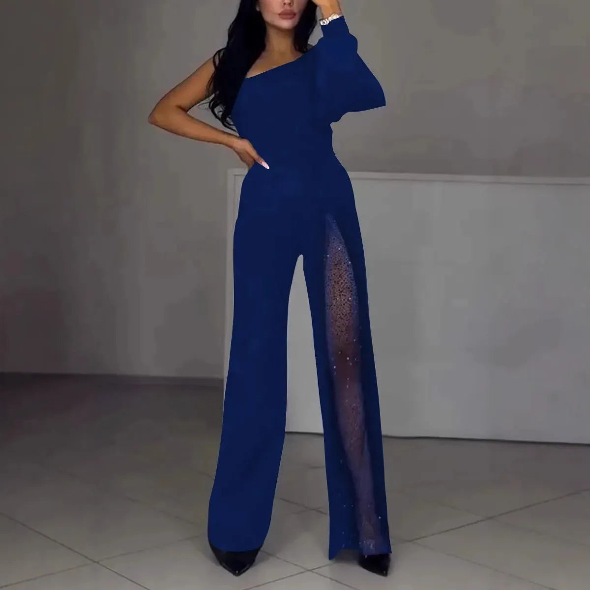 Women's black polyester jumpsuit with oblique shoulder design and high slit, showing mid-waist and long sleeves