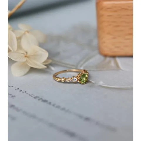 Quadrilateral geometric copper ring with imitation peridot stone, showing angular design and metallic finish