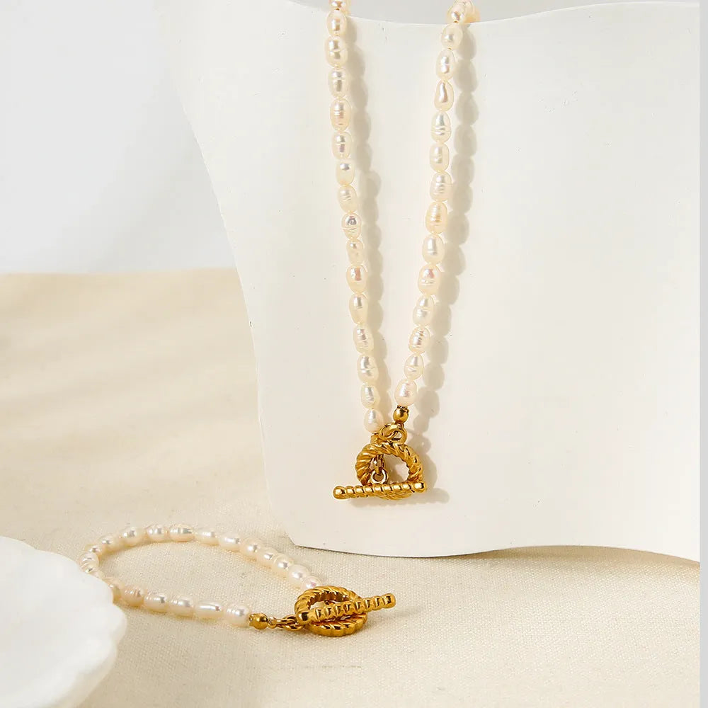 Freshwater pearl and stainless steel geometric pendant necklace and matching bracelet set for women.