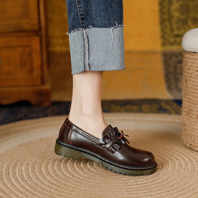 Women's black leather shoes with round toe and chunky flat heel in British style.