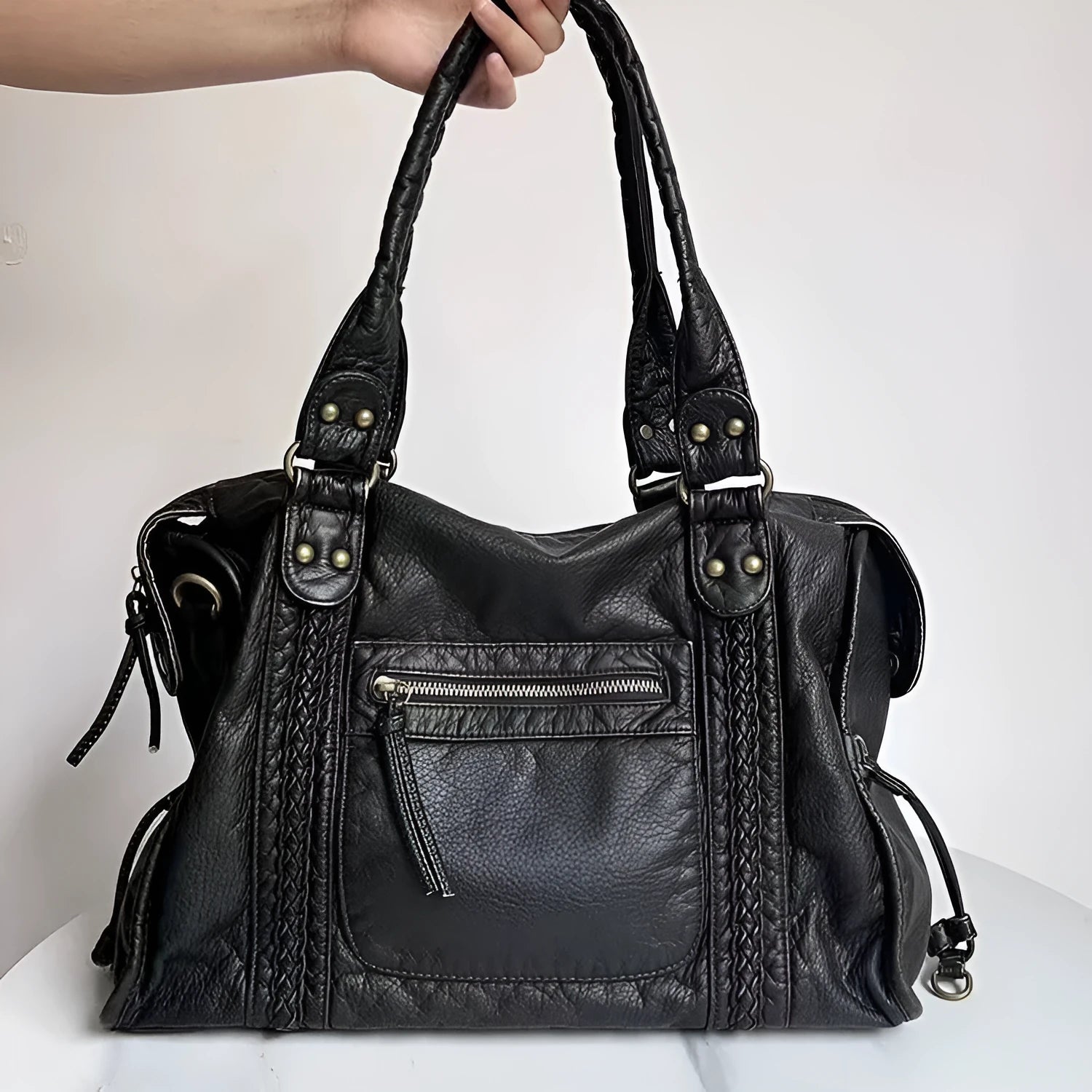 Women's retro messenger bag in bright black with golden edge, showing internal zipper compartments and weaving details