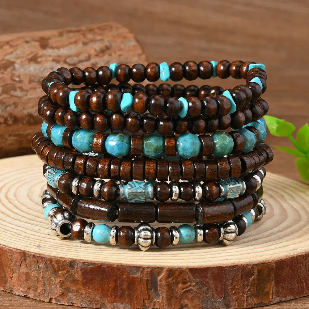 Seven multicolour retro bracelets with round wooden beads and alloy details laid out flat.