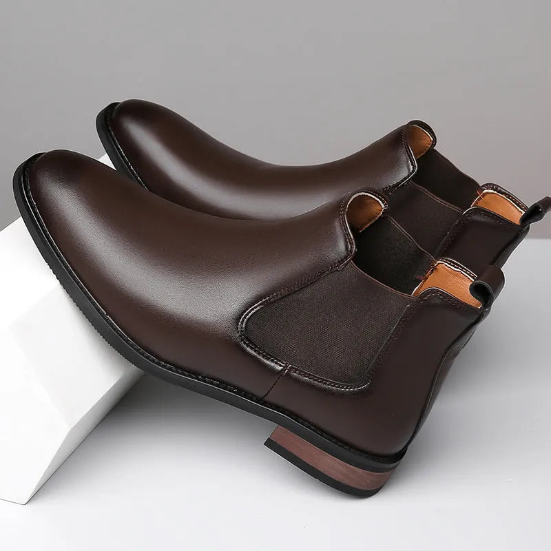 Men's black pointed toe Chelsea boots with a high-top design and decorative stitching on a rubber sole.