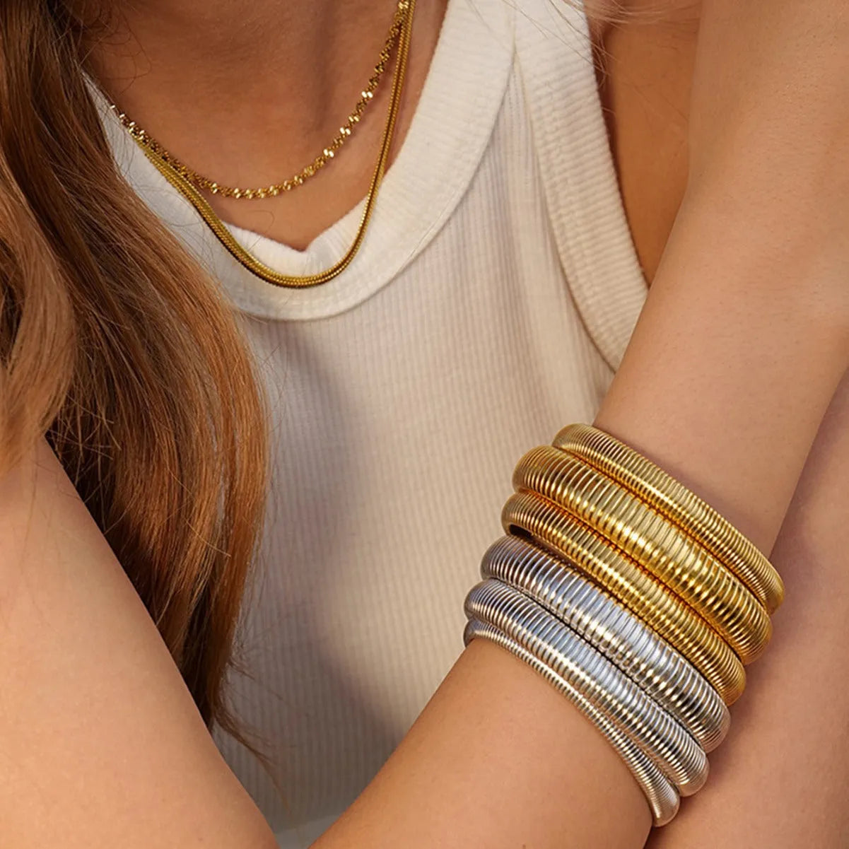 Women's elastic titanium steel bracelet with vertical stripe and ring design in gold or silver, showing adjustable width options.