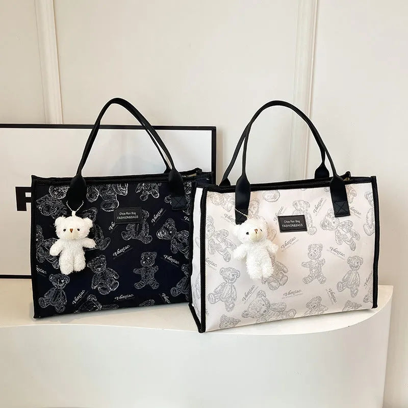 Women's black canvas tote with rhombus pattern showing 40cm width and horizontal square shape with shoulder strap