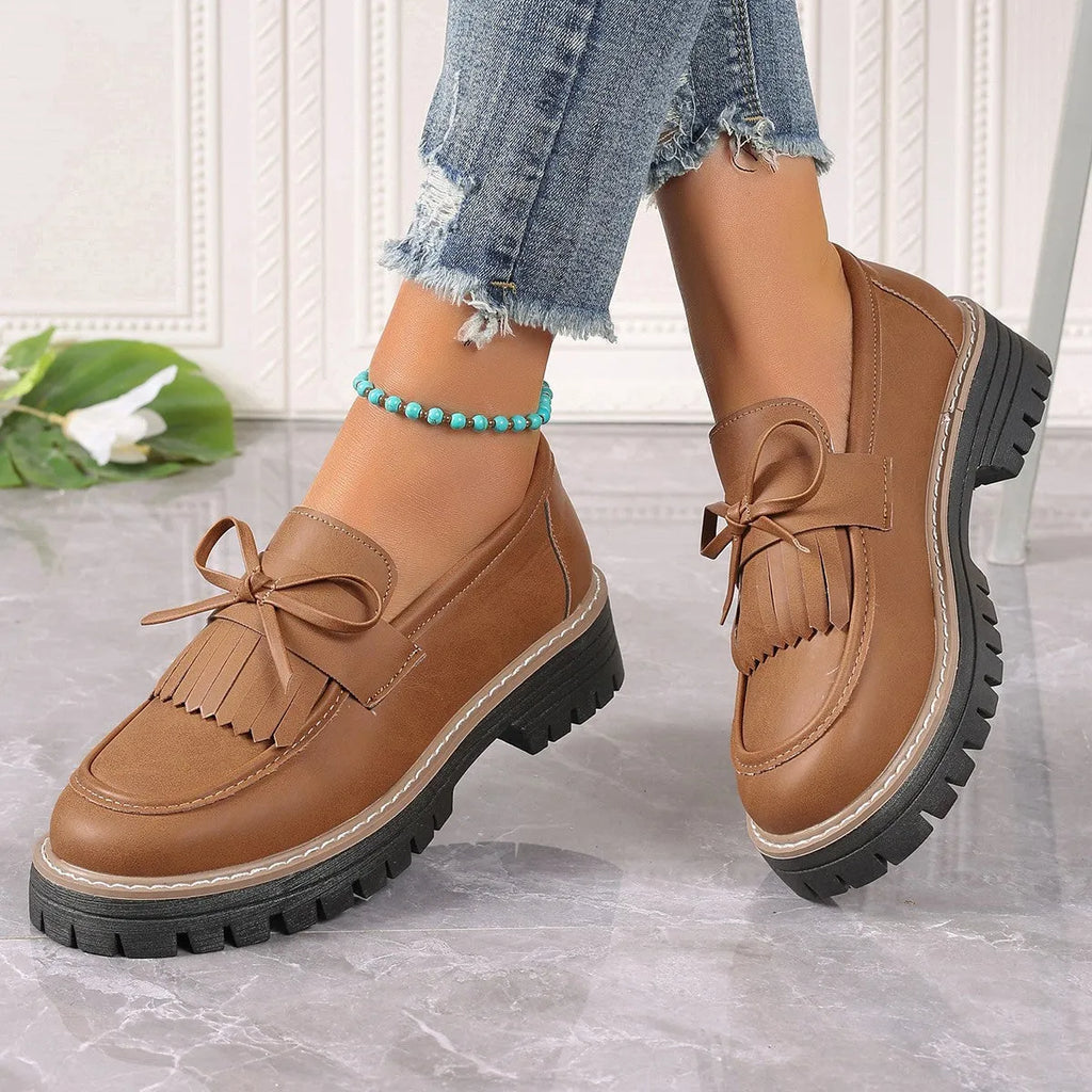 Women's black plus size loafers with tassel and bowknot, chunky heel, and round toe on a rubber sole