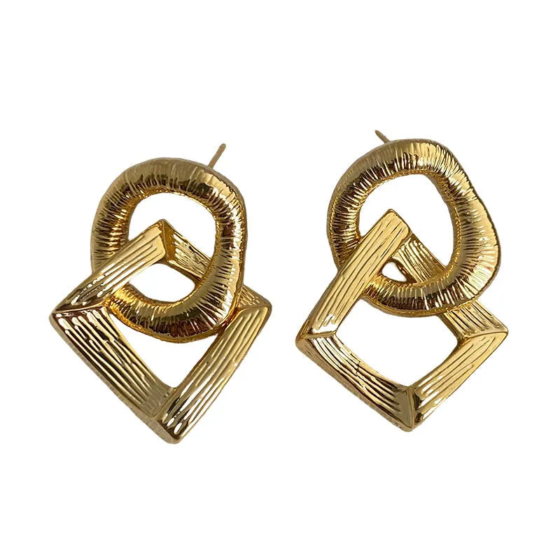 Retro geometric circle pendant earrings with a long drop, shown in gold and silver colour options.