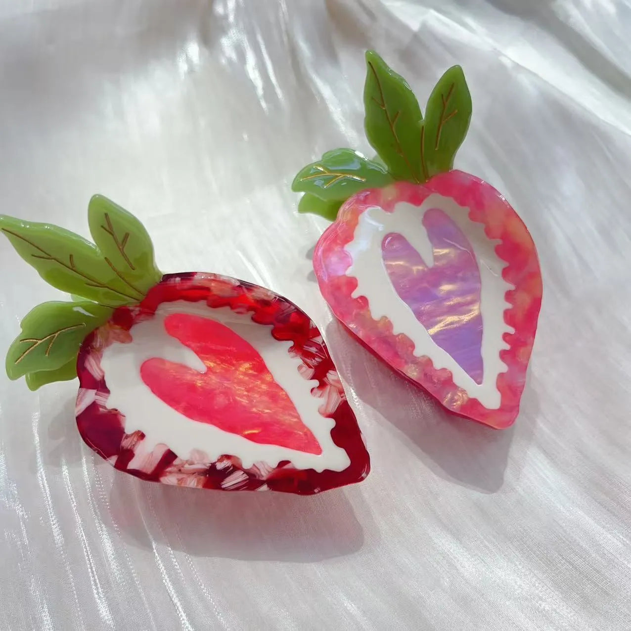 Handmade red strawberry hairpin with pastoral style design on a pink background