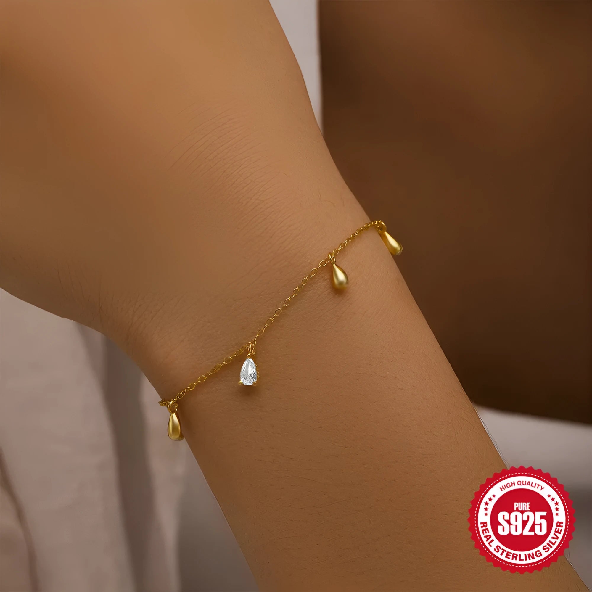 S925 sterling silver bracelet with gold colour finish and a geometric water drop diamond pendant.