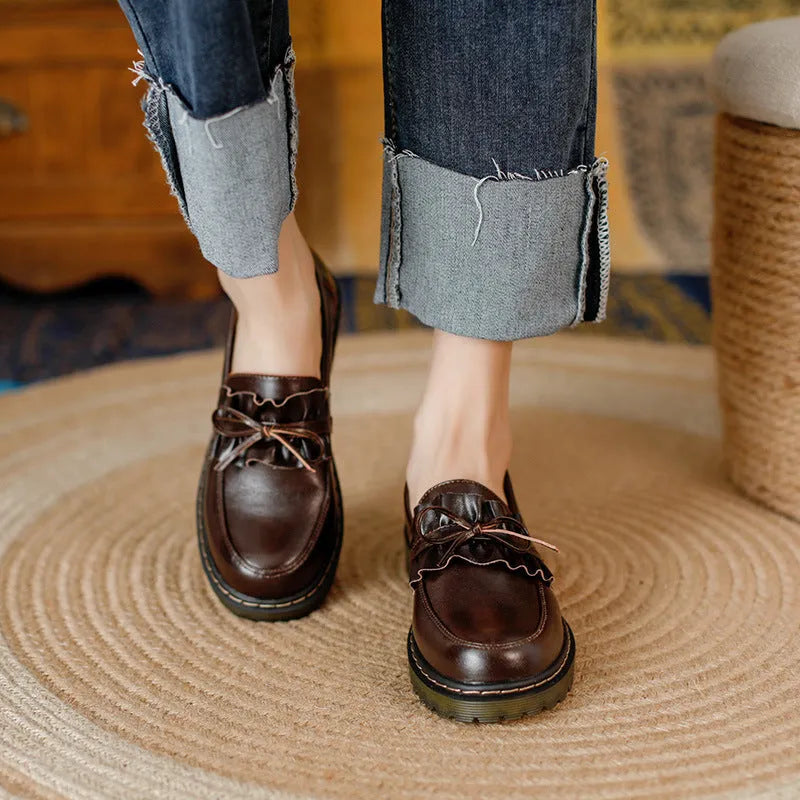 Women's black leather shoes with round toe and chunky flat heel in British style.
