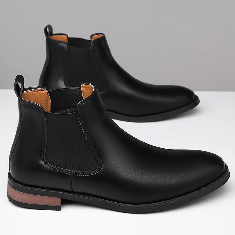 Men's black pointed toe Chelsea boots with a high-top design and decorative stitching on a rubber sole.