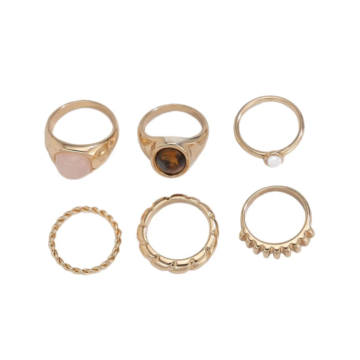 Six irregular geometric alloy rings in light gold colour arranged for display