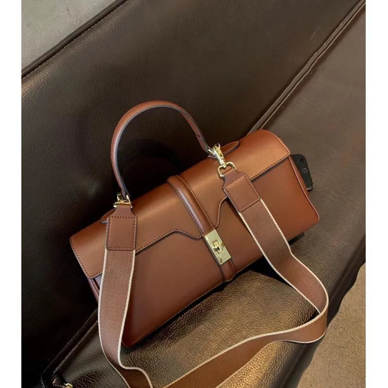 Women's cylindrical cowhide leather messenger bag in black or caramel colour with retro styling
