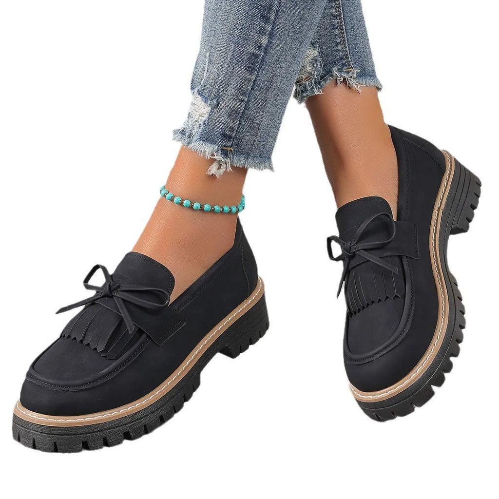 Women's black plus size loafers with tassel and bowknot, chunky heel, and round toe on a rubber sole