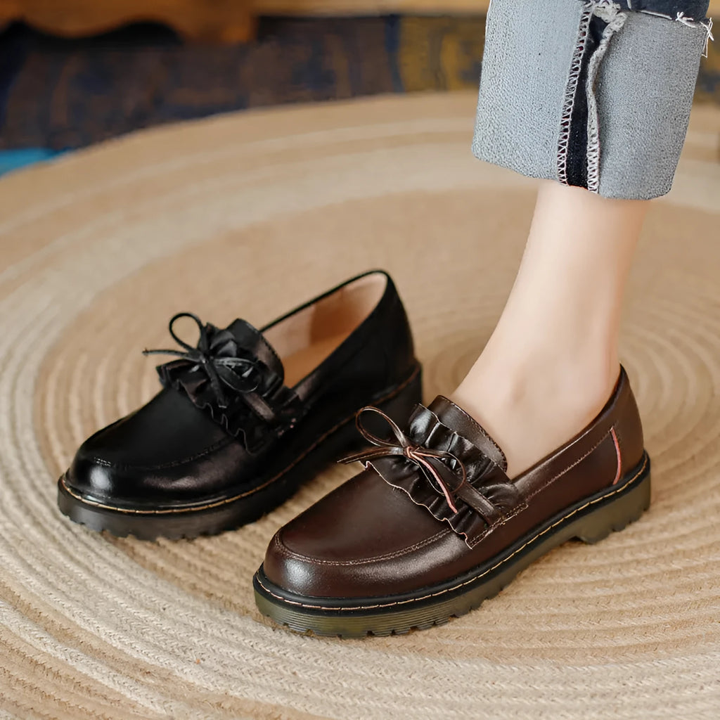Women's black leather shoes with round toe and chunky flat heel in British style.